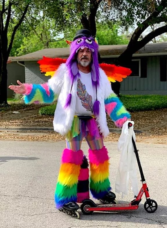 Fritz Blaw, founder of Motorblade Postering, in his rainbow furry costume holding a kick scooter